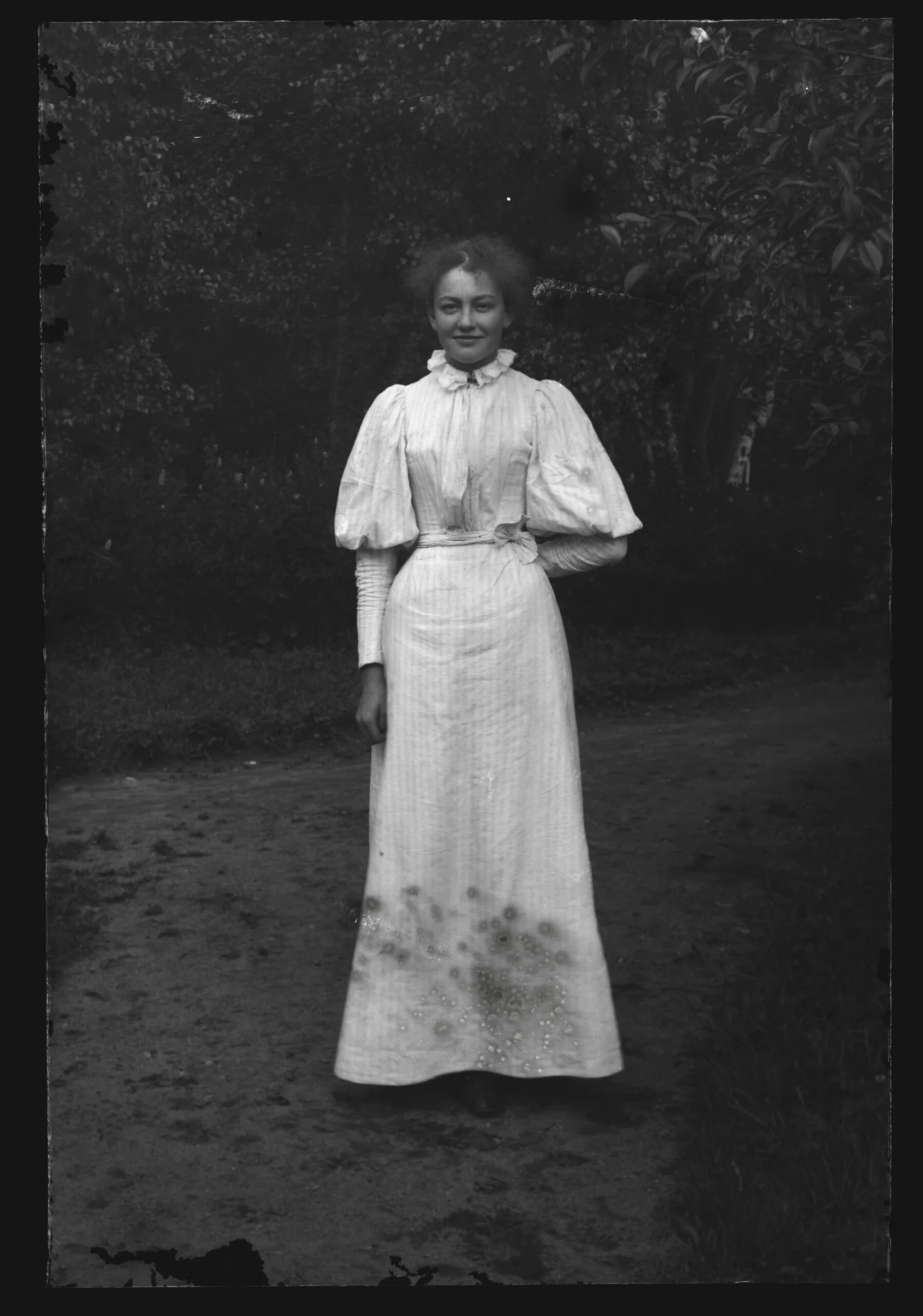 En kvinna i klänning poserar för bild.