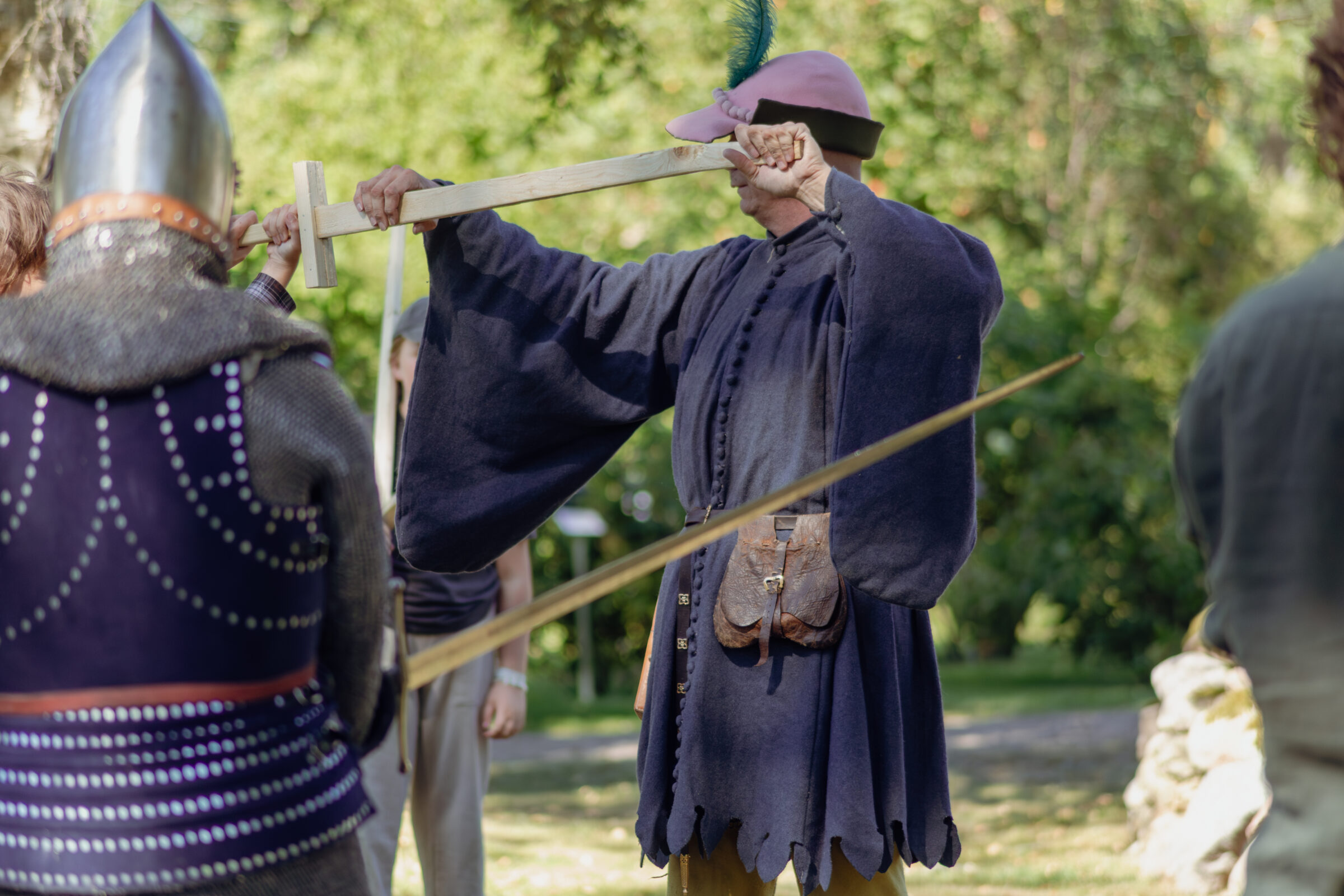 En person i medeltidskläder demonstrerar svärdsfäktning.